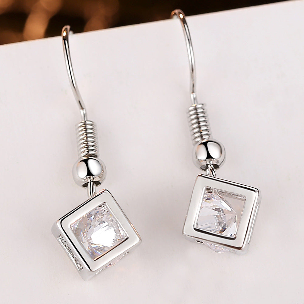 Ensemble collier et boucles d'oreilles en forme de cube sertis de zircons cubiques.